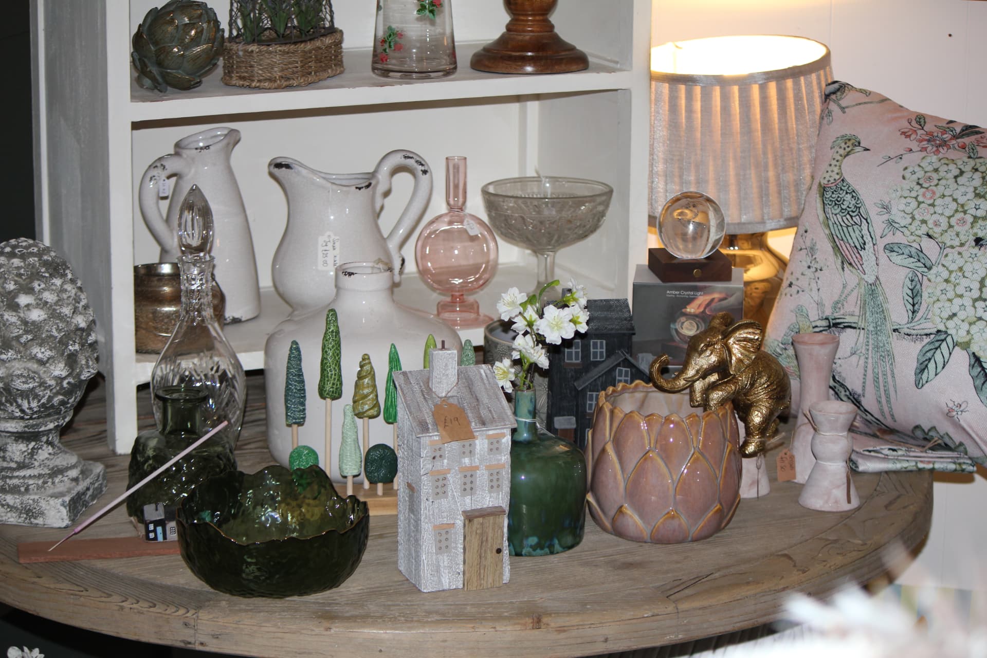 A round table styled with vases, bowls and candlesticks