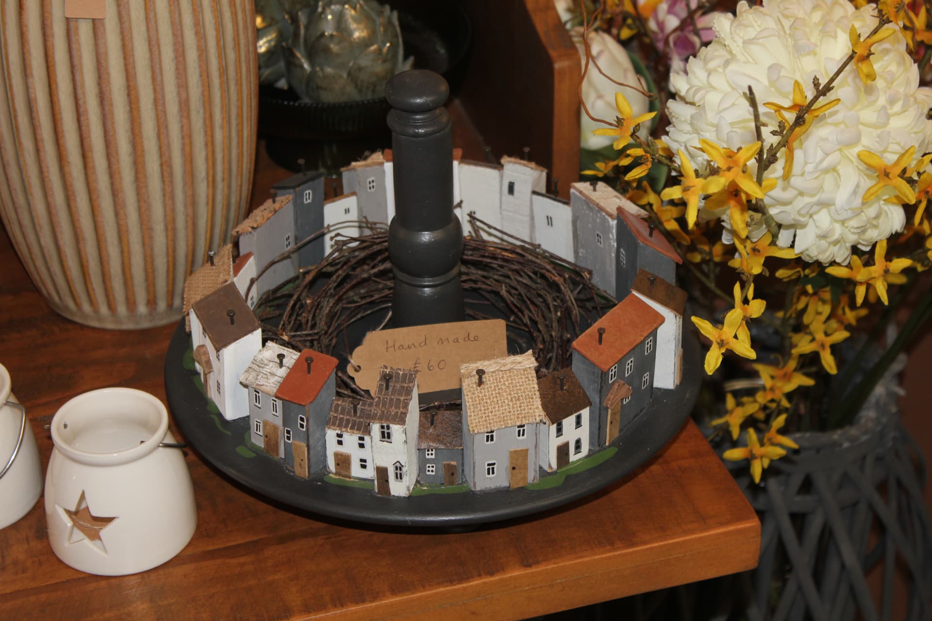 A handmade wooden village scene on a painted platter